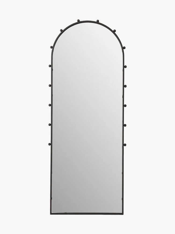 Arched floor mirror with black frame that has spherical accents around the top two thirds.